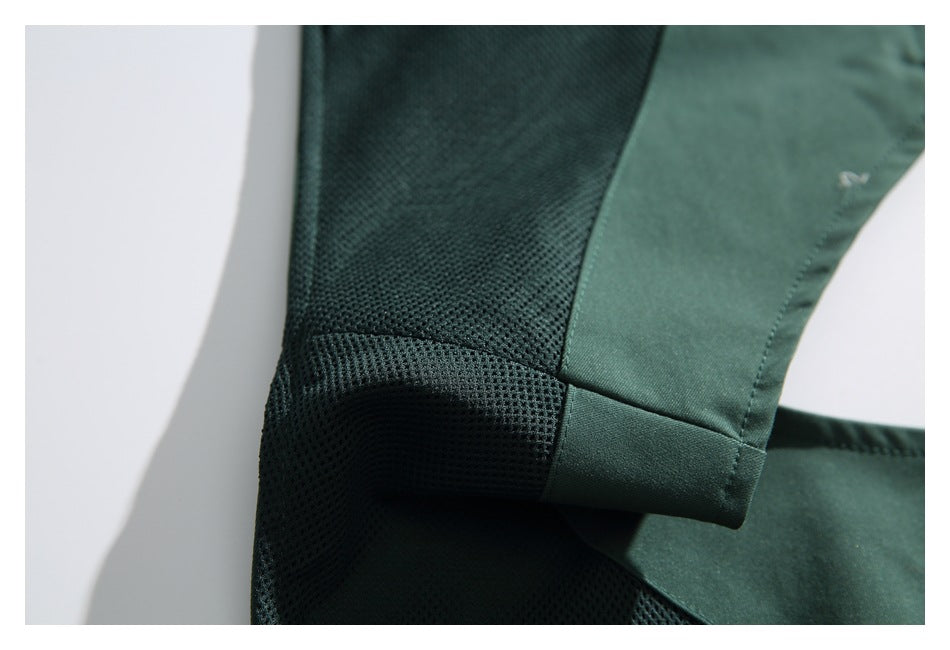 Close-up of dark green mesh fabric meeting a solid green panel at a stitched seam.