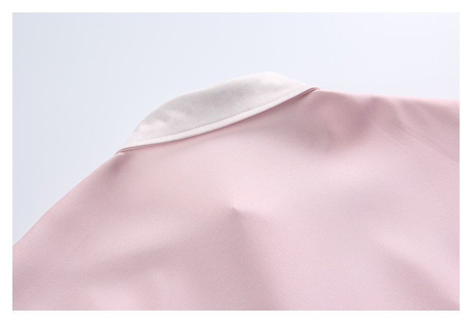 Close-up of the back of a pale pink shirt, showing its contrasting white collar.