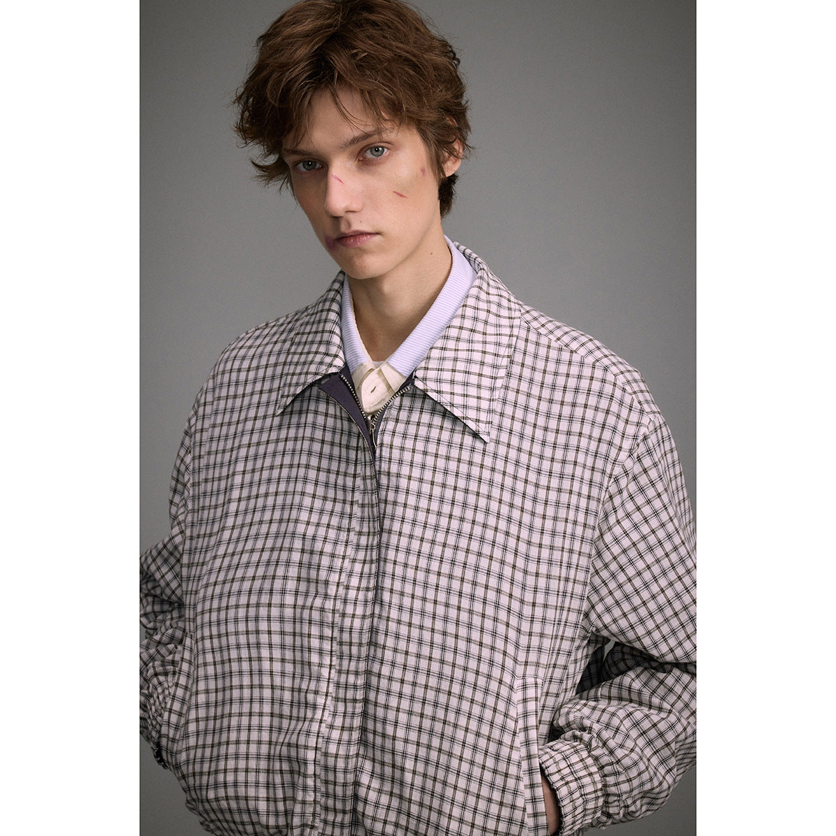 Model wearing a light plaid zip-front jacket with a wide collar and elastic cuffs.