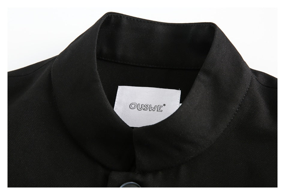 Close-up of a black garment's folded collar and white sewn-in label.