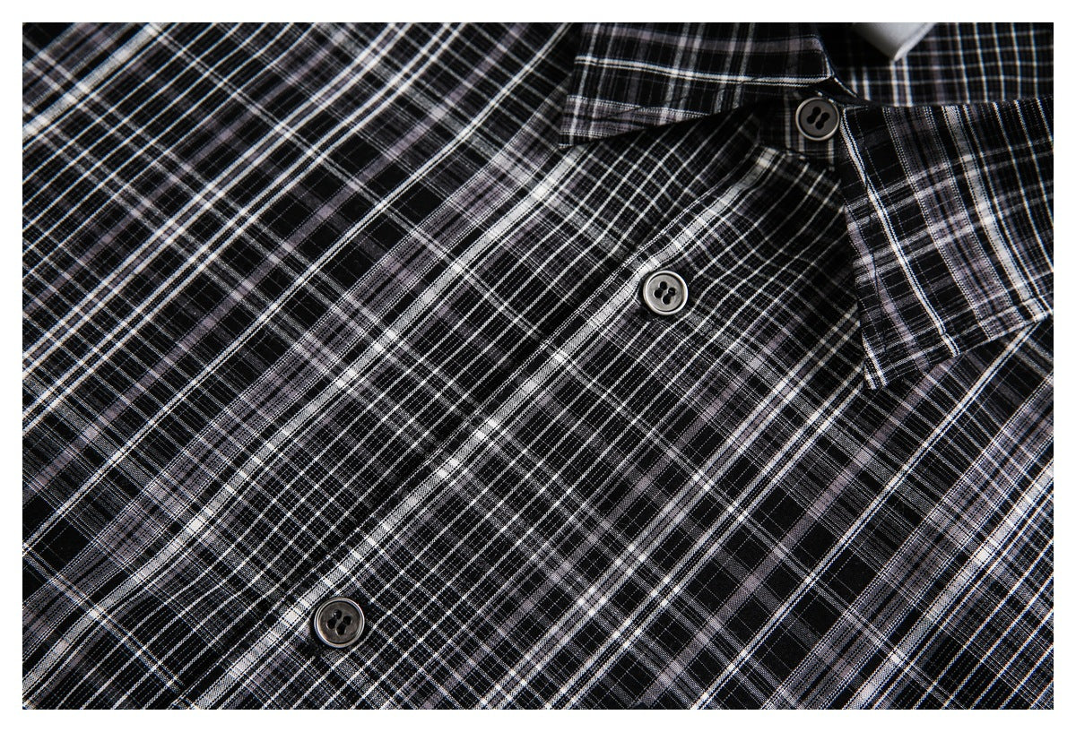 Close-up of a black-and-gray plaid shirt collar and button placket with dark buttons.