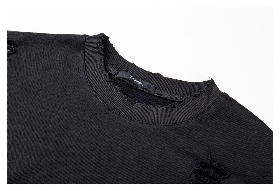 Close-up of the black sweatshirt's distressed crewneck edge, inner neck label, and a small distressed opening.