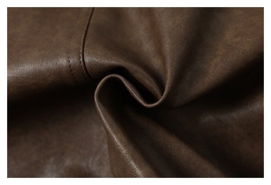Close-up of brown pebbled garment material gathered into a soft fold.