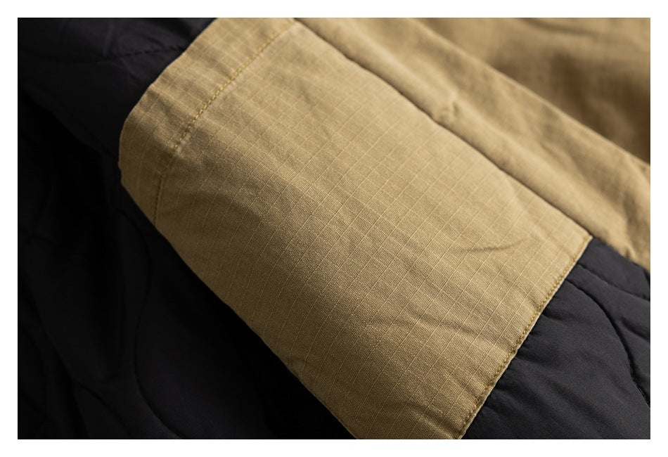 Close-up of an olive-brown jacket sleeve laid over black fabric.