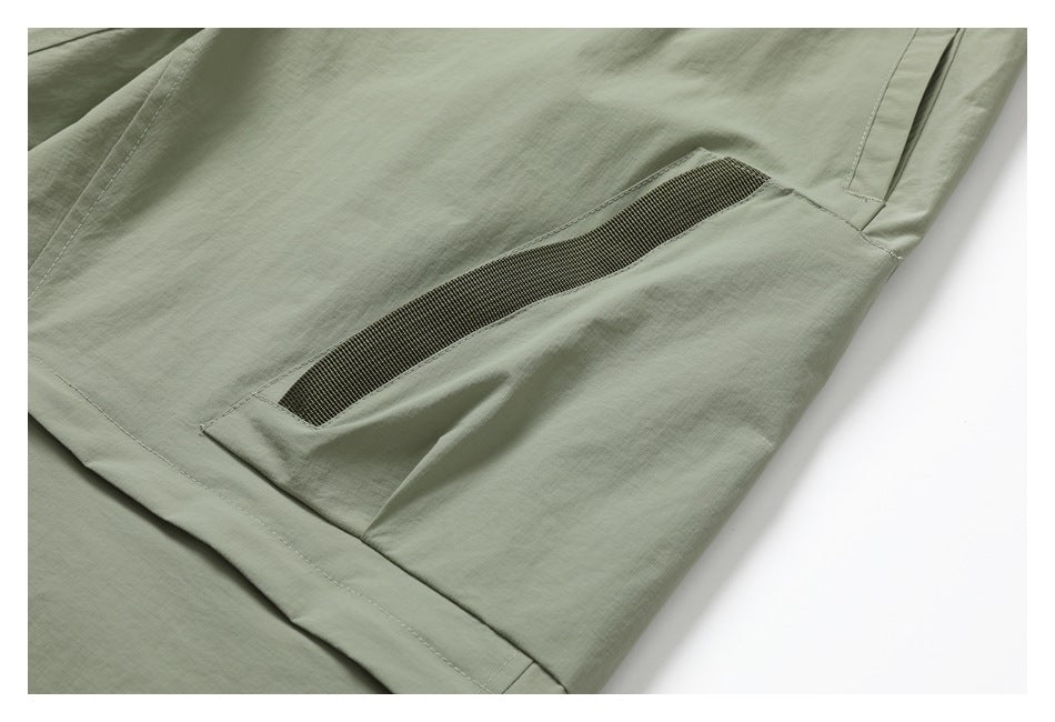 Close-up of sage pants showing a large pocket with a dark mesh panel and surrounding seams.