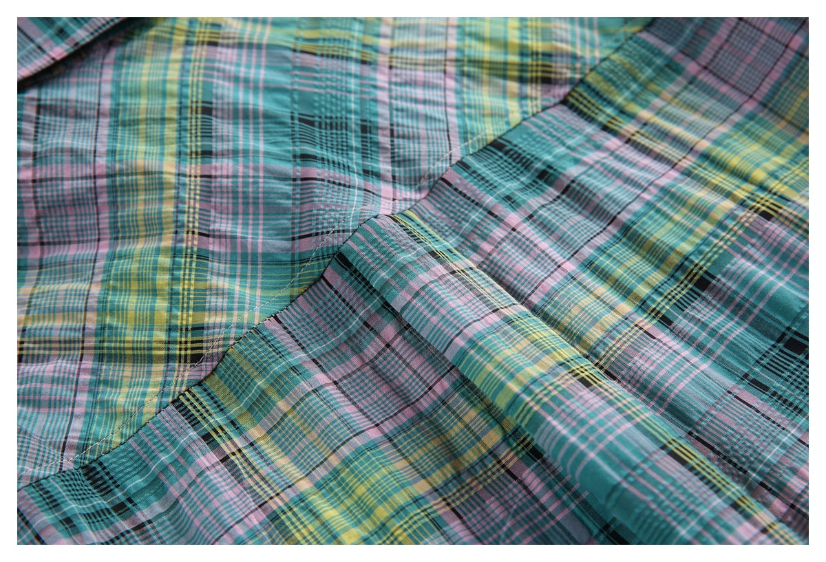 Close-up of the plaid shirt's back yoke seam and gathered fabric.
