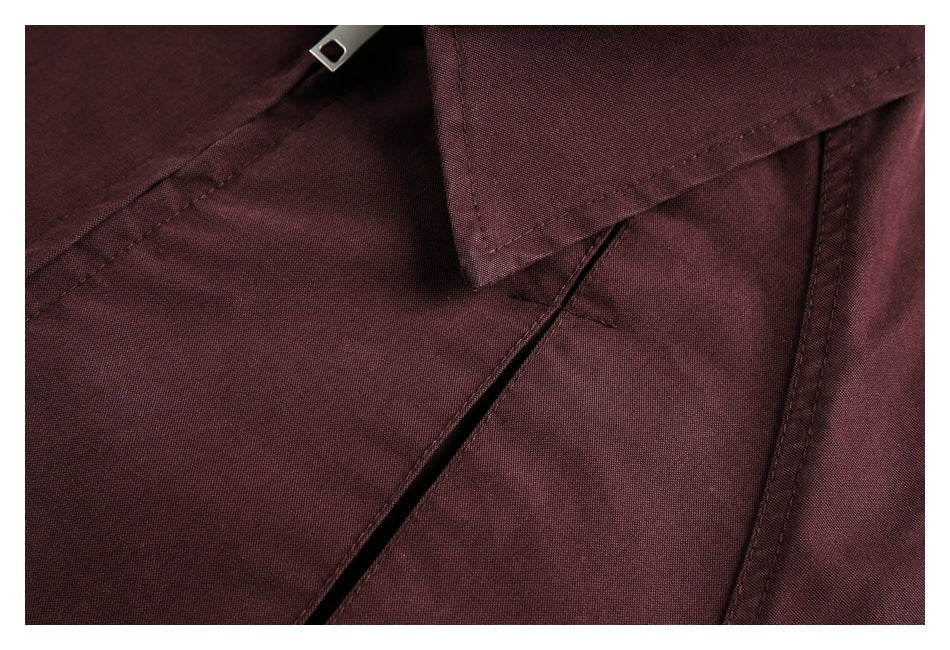 Close-up of the burgundy jacket's front seam and angled pocket opening.
