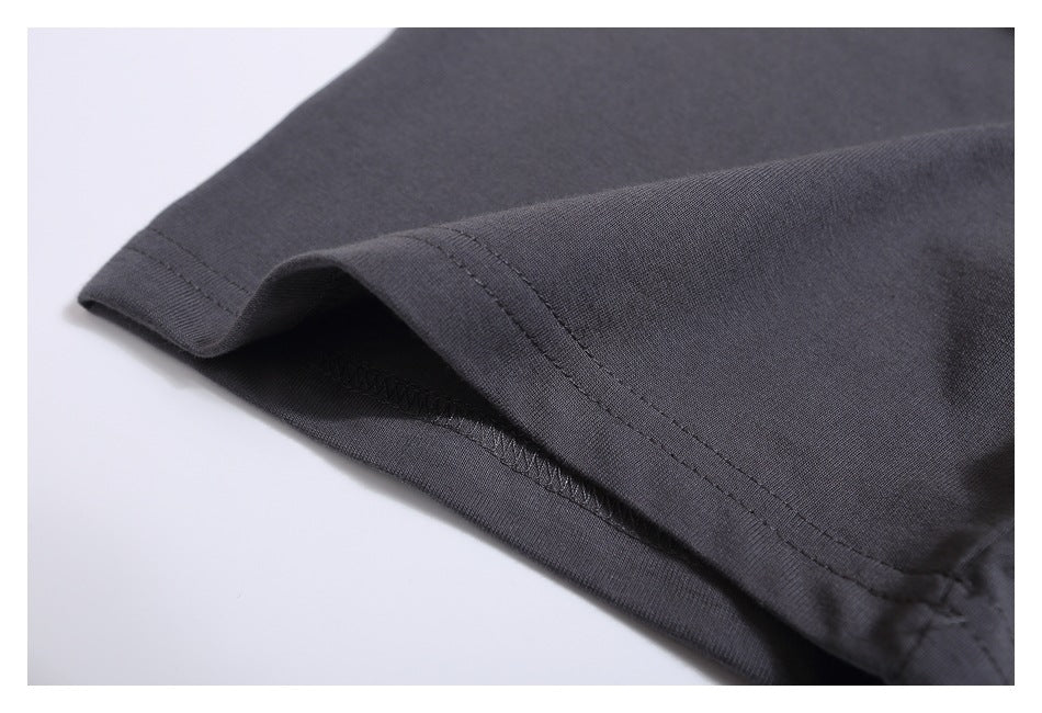 Close-up of the charcoal gray T-shirt sleeve hem, showing folded fabric and stitching.