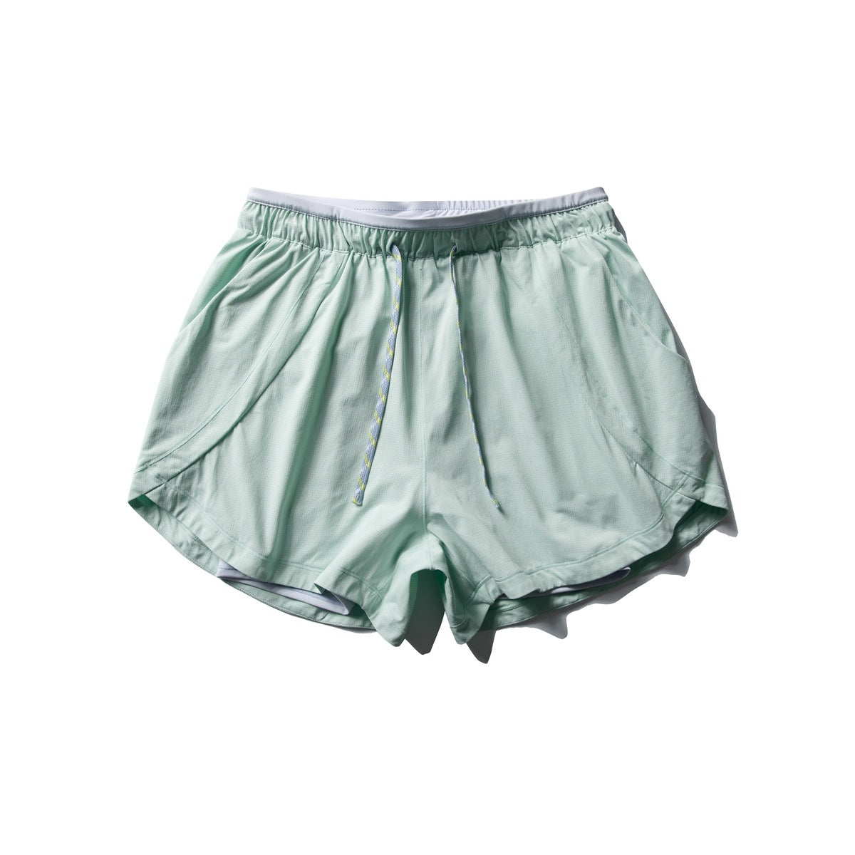 Mint green athletic shorts with braided drawcord, side pockets and curved hem, laid flat, front view