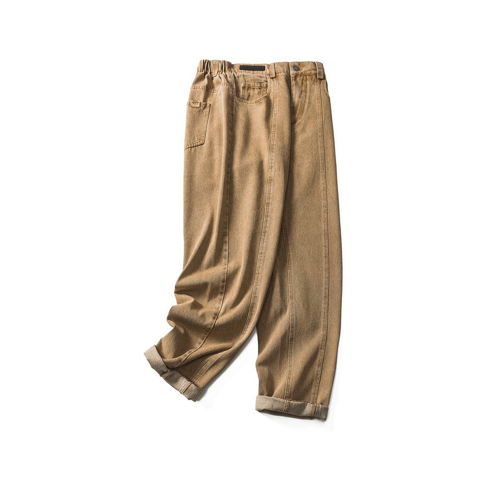 Full view of tan washed jeans laid flat, with a gathered waistband, front pockets, and rolled cuffs.