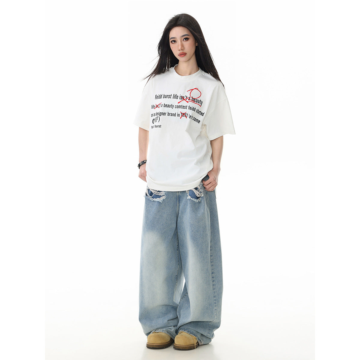 Model wearing an oversized off-white T-shirt with black text and red graphics, paired with very wide light-wash jeans.
