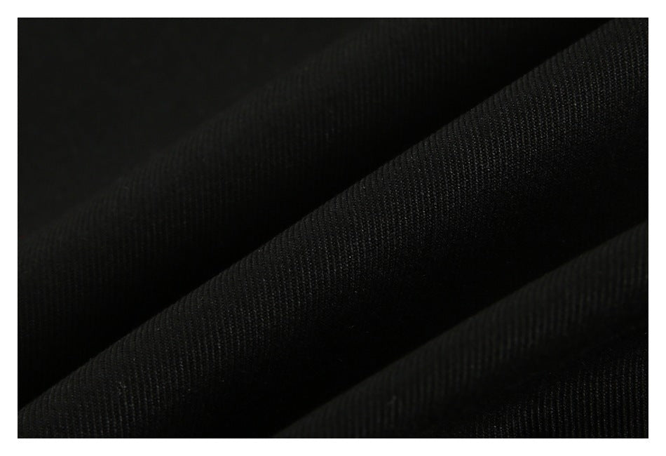 Close-up of black fabric with a fine diagonal weave and soft folds.