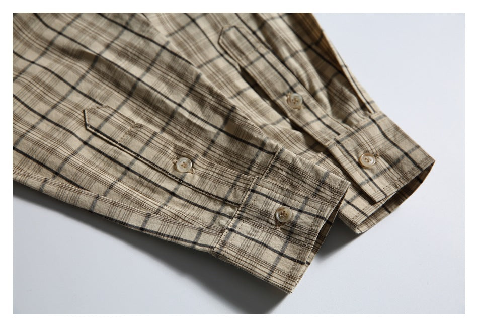 Close-up of a beige plaid shirt sleeve cuff with buttons and button placket.