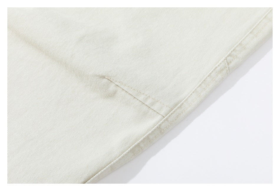 Close-up of a small welt pocket and seam on light beige trousers.