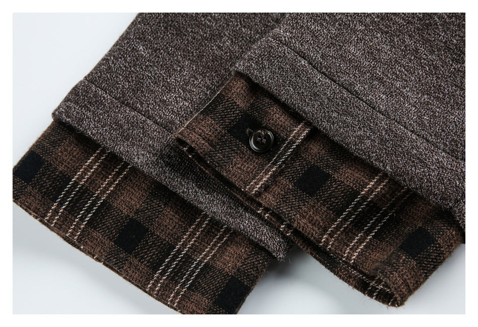 Close-up of a brown jacket cuff with a button and exposed brown plaid lining.