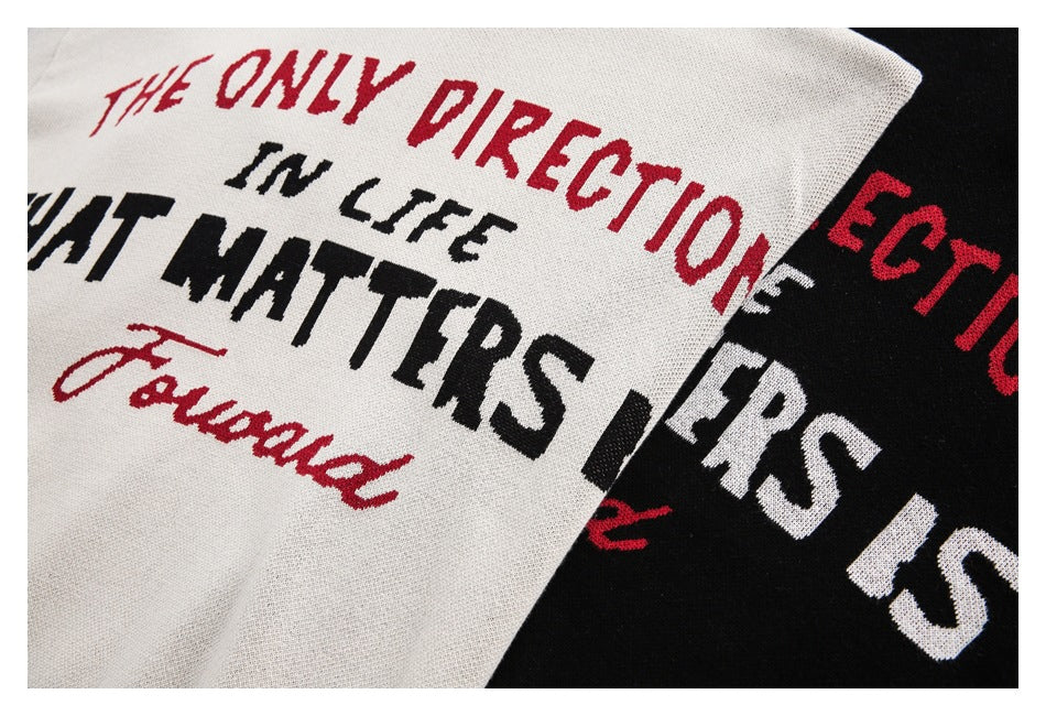 Close-up of red, black, and white English lettering on overlapping light and black sweaters.