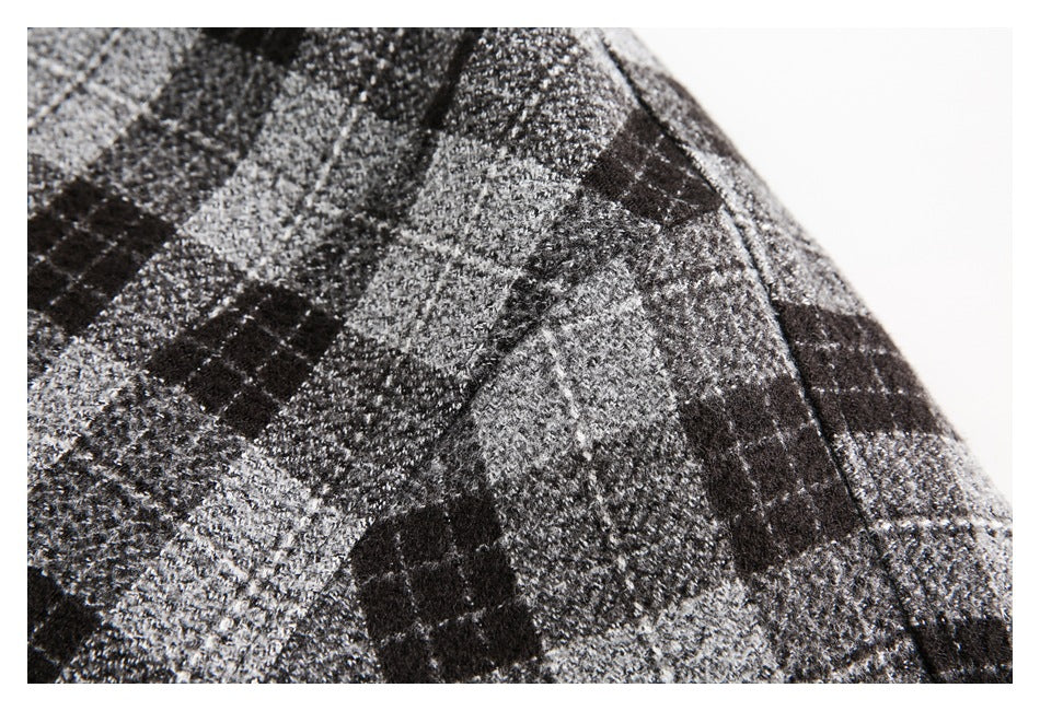 Close-up of a shoulder seam and the jacket's textured black, gray, and white plaid fabric.