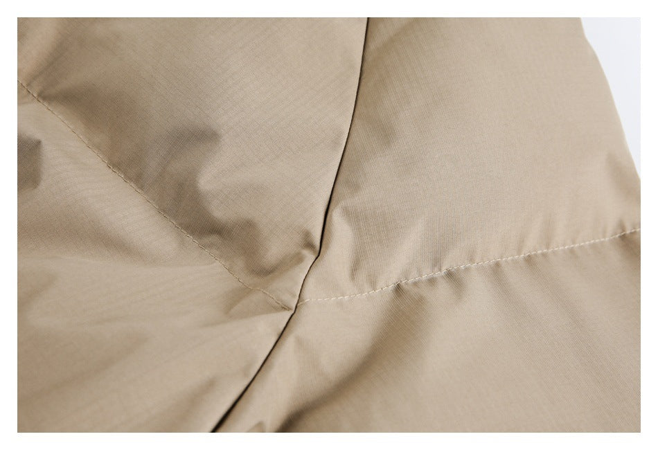 Close-up showing intersecting stitched seams on tan garment fabric.