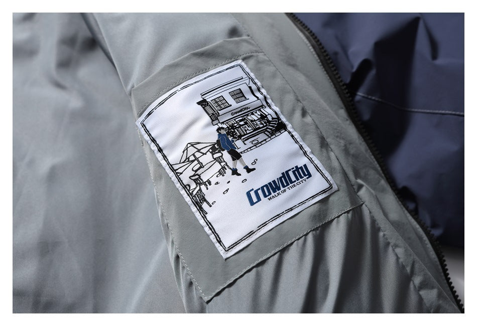 Close-up of a sewn patch on the gray jacket lining, showing an illustrated street scene and English lettering.