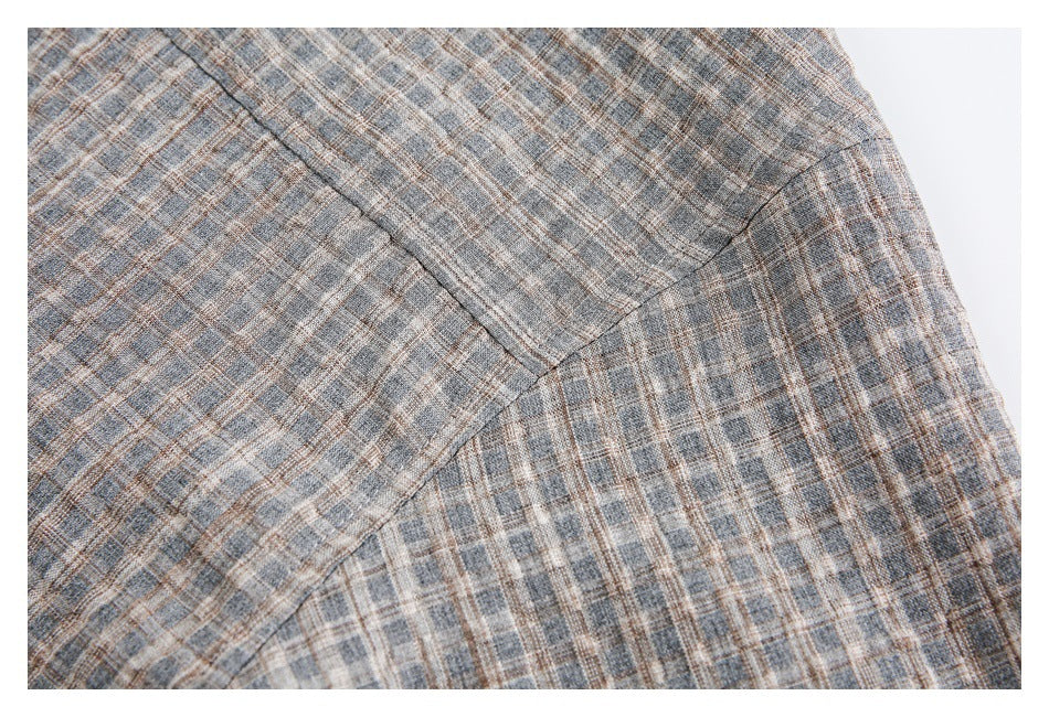 Close-up of the plaid shirt's shoulder and sleeve seams.