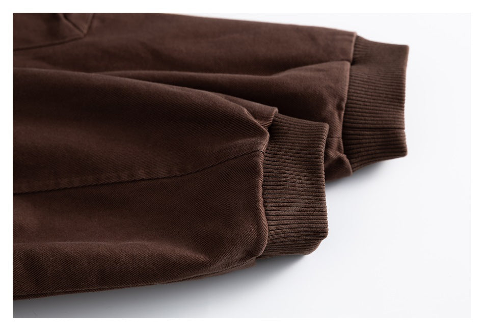 Close-up of two dark brown jacket sleeves with ribbed knit cuffs.