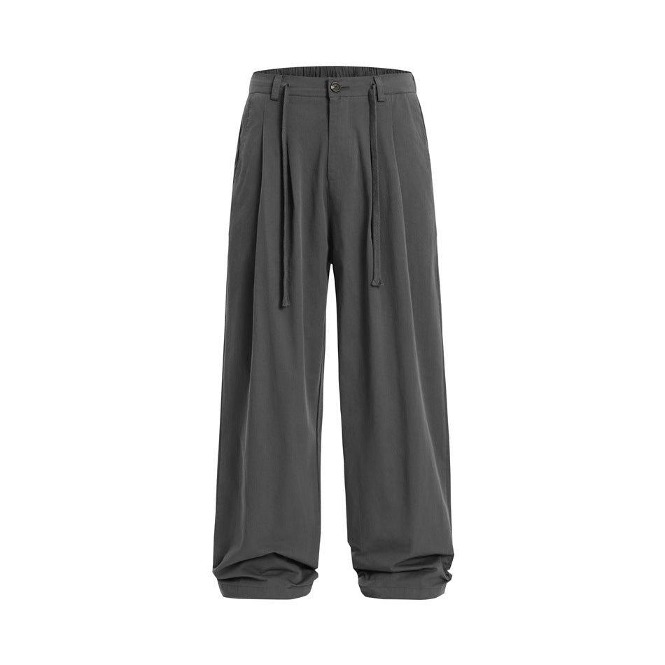 Gray wide-leg pleated trousers with button front and long drawcord ties, flat front view