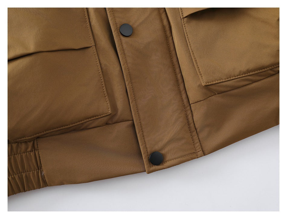 Close-up of the tan jacket's snap-button front placket and large lower pockets.