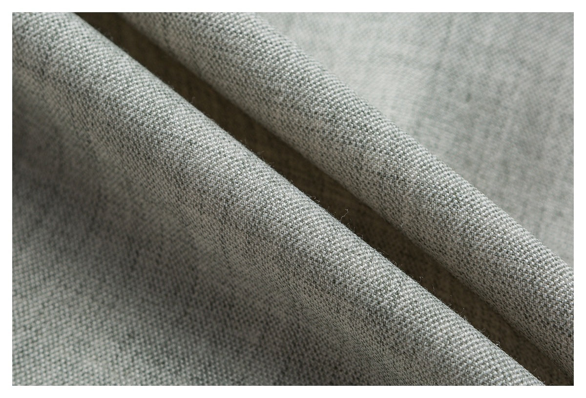 Macro view of the textured weave of light gray shirt fabric.