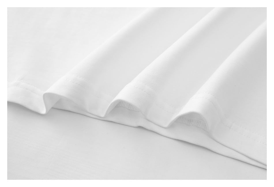 Close-up of the white T-shirt’s hem with visible stitching and folded fabric.