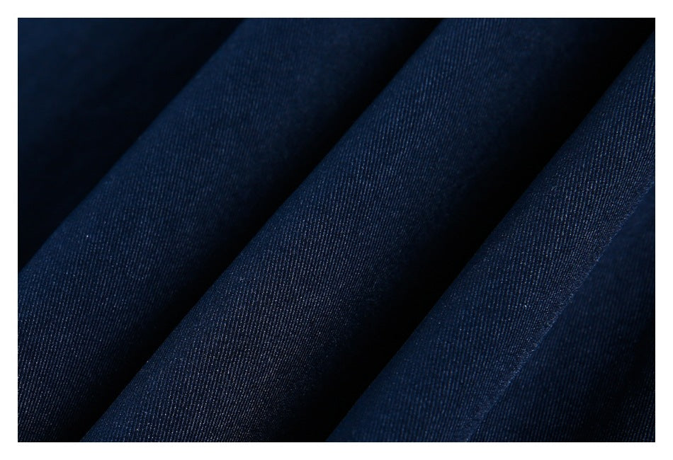 Macro view of dark navy garment fabric folded to show its fine diagonal weave.
