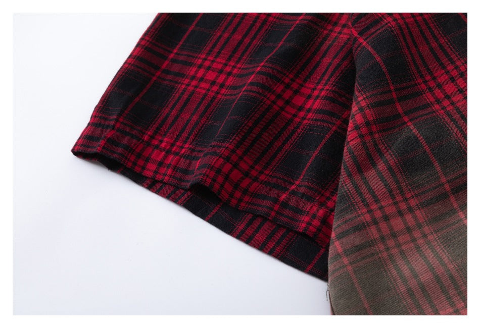 Close-up of a red and black plaid garment hem with visible stitching and overlapping fabric.