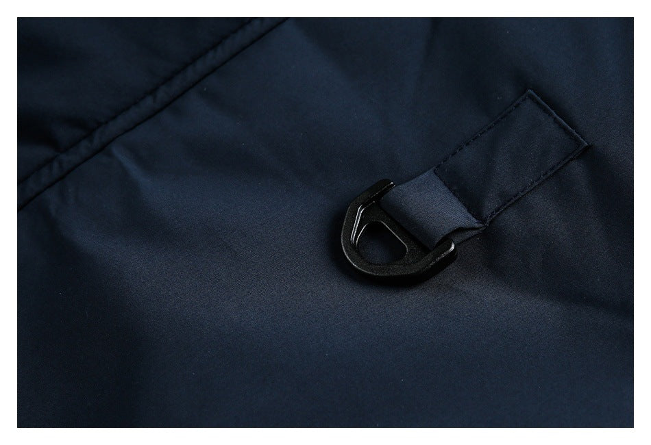Close-up of a dark navy coat showing a black hook fastener attached to a fabric loop.