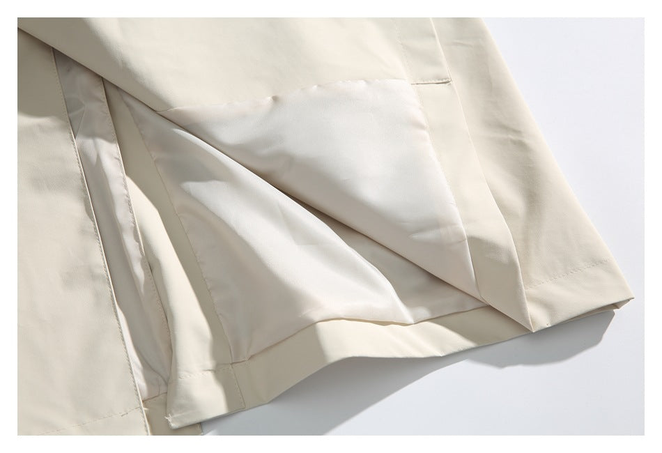 Close-up of the ivory coat's inner lining and stitched hem.