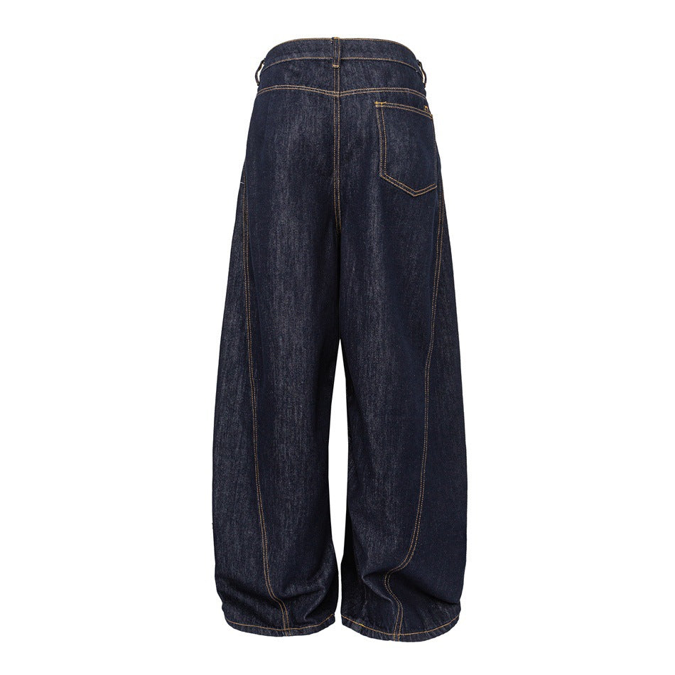 Back of dark indigo wide-leg jeans with one patch pocket, curved leg seams and golden topstitching