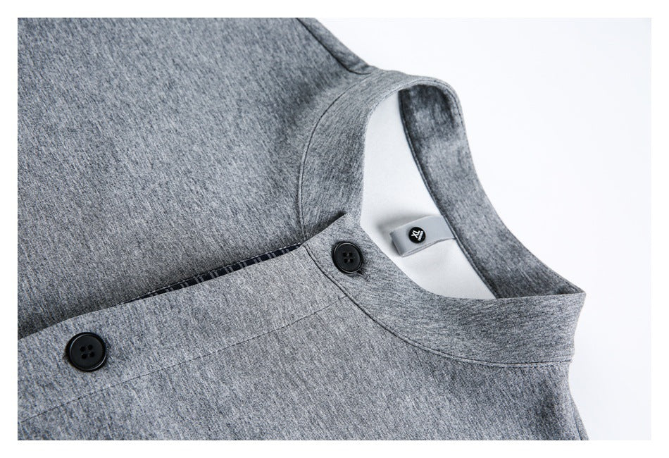 Close-up of a gray garment's band collar and buttoned tabs, with a small inner label visible.