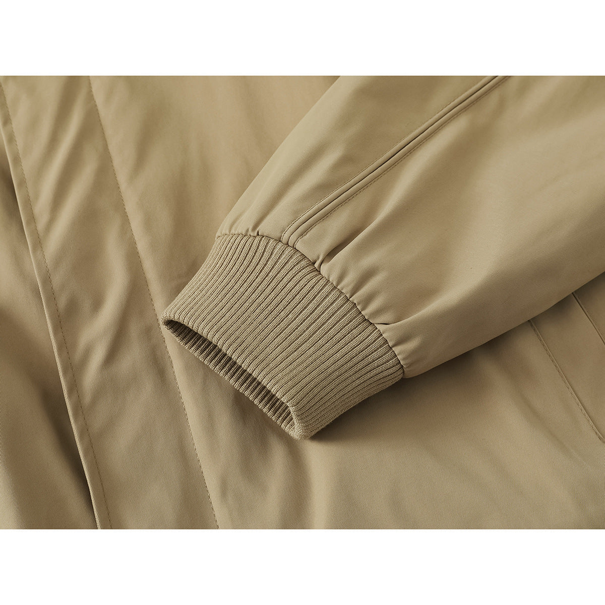 Close-up of a tan jacket sleeve ending in a wide ribbed cuff.