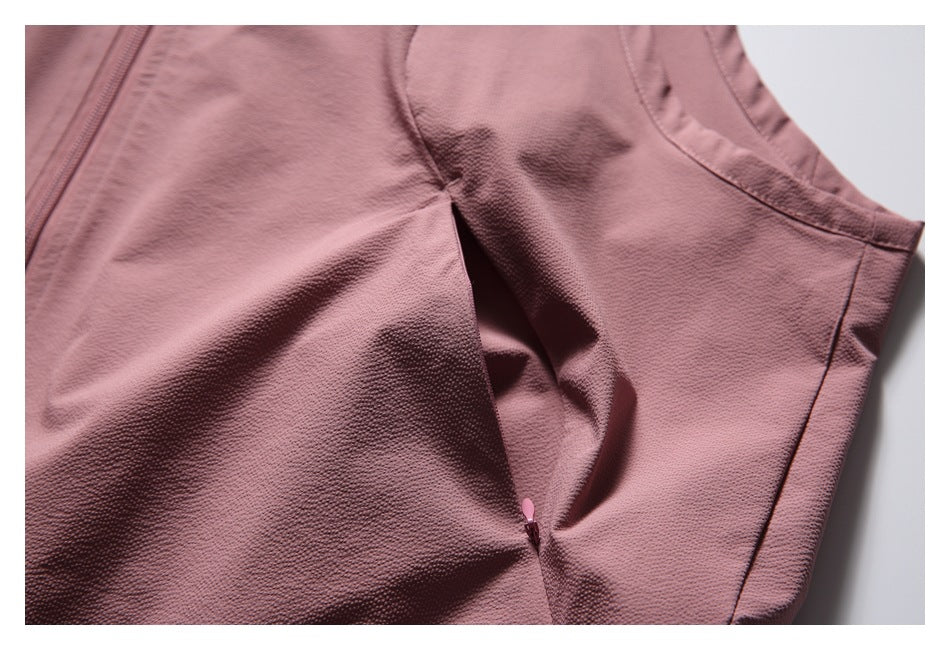 Close-up of a side seam and small zipper opening on the dusty rose vest.