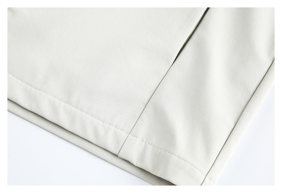 Close-up of the ivory garment's stitched hem and intersecting panel seams.