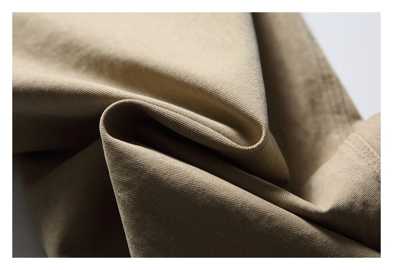 Close-up of the beige garment fabric folded to show its surface and texture.