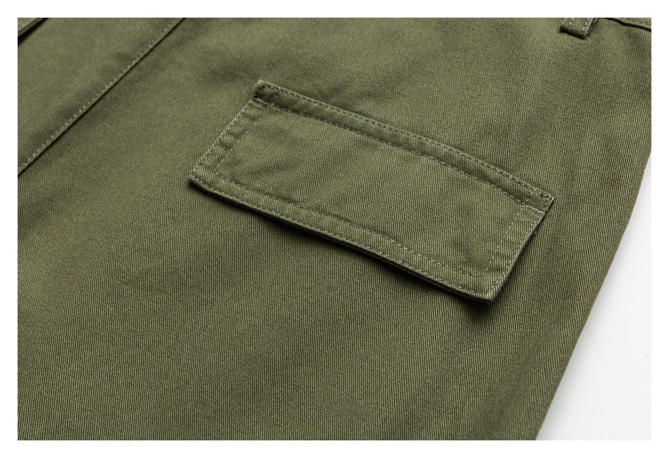 Close-up of a rectangular back pocket on olive-green trousers with visible stitching.