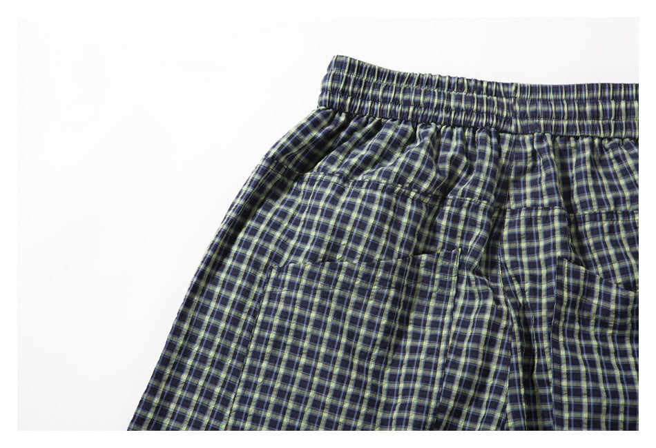 Close-up of the back elastic waistband and patch pocket on the plaid shorts.