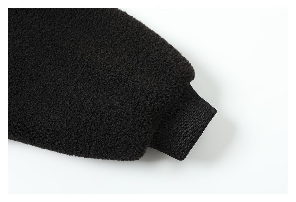Close-up of the black textured jacket sleeve ending in a ribbed cuff.