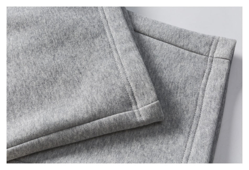 Close-up of gray heathered pants showing a folded hem and stitched seam.