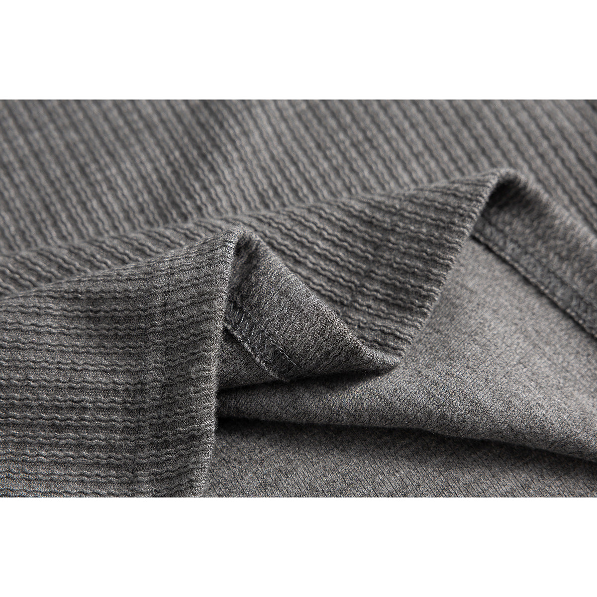 Close-up of gray ribbed fabric folded to show its textured surface and reverse side.