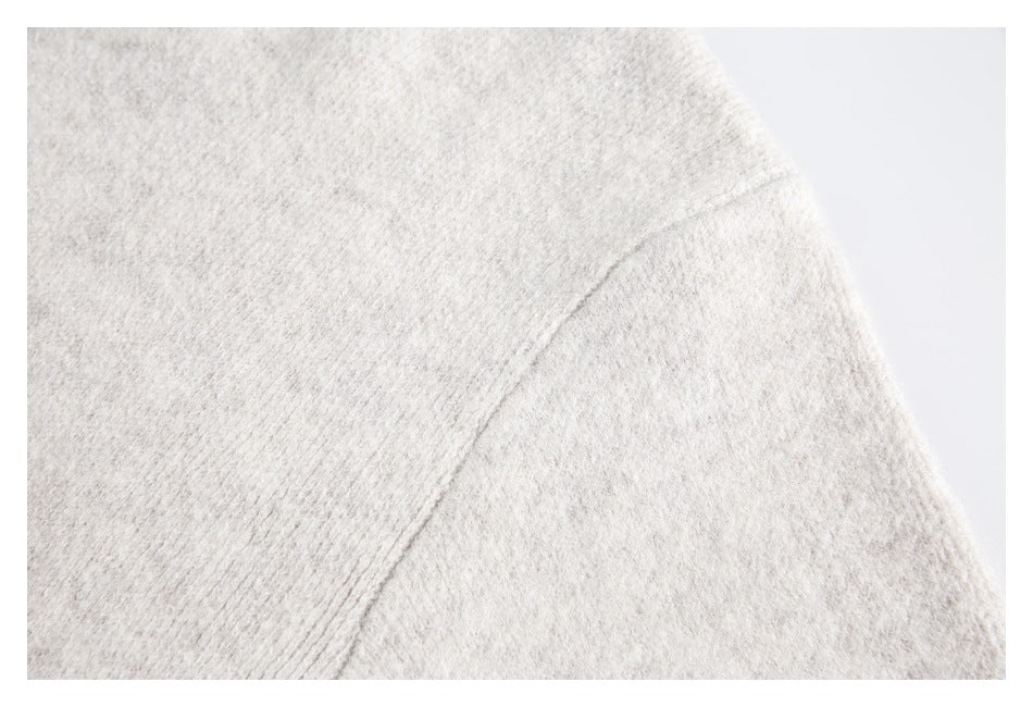 Close-up of the light gray sweater's shoulder seam and fuzzy knit texture.