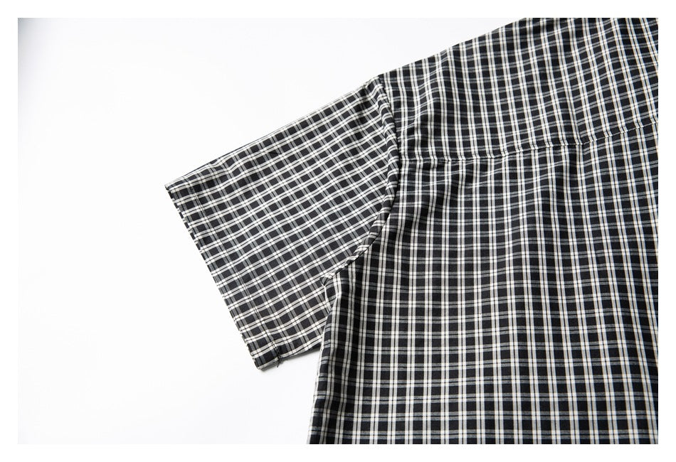 Close-up of the sleeve seam and back yoke on a black-and-white plaid shirt.