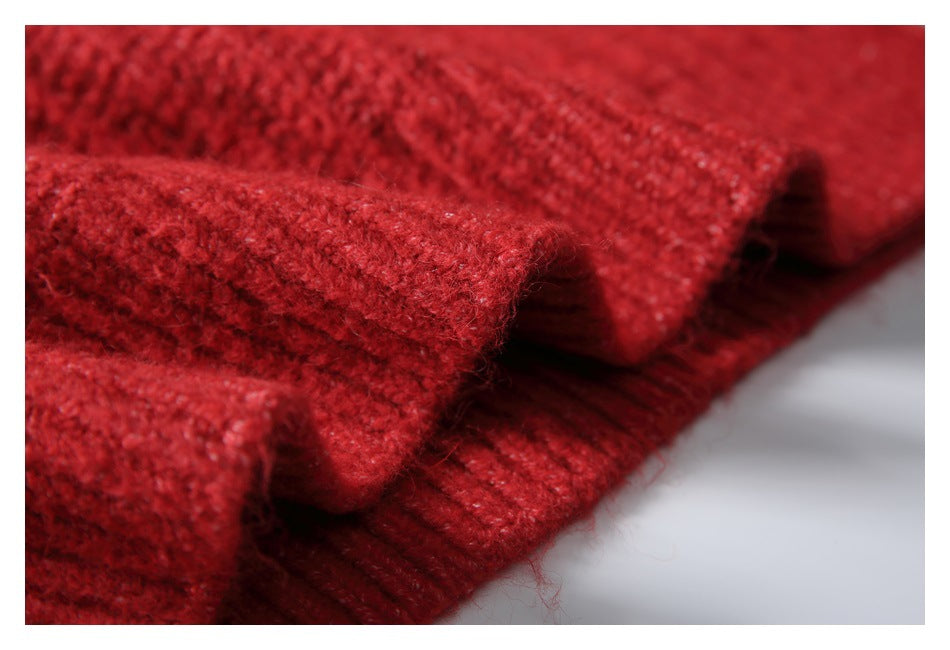 Close-up of folded red knit sweater edges with a ribbed band and textured stitching.