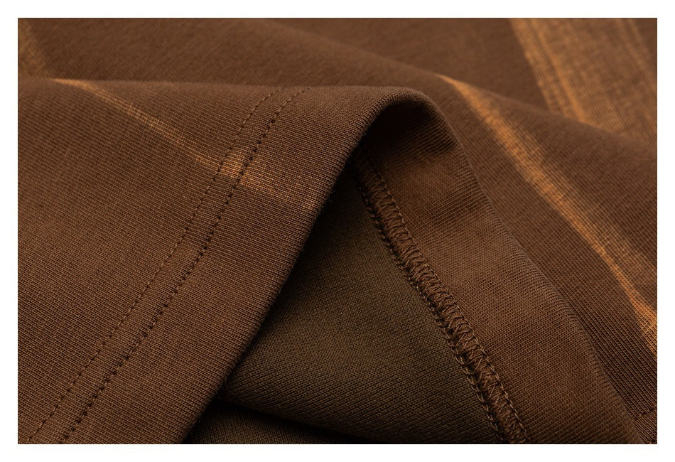 Close-up of a brown striped garment hem with visible stitching and seam finishing.