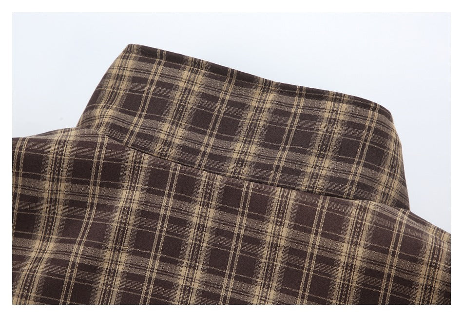 Close-up of the brown plaid garment fabric and folded collar area.