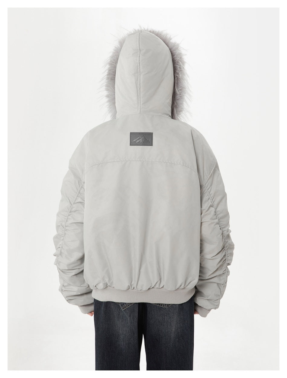 Rear view of a model wearing a light gray hooded jacket with a fur-trimmed hood and gathered sleeves.